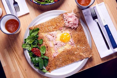 Una galette completa con los lados doblados hacia adentro formando un cuadrado y el huevo y el queso en el medio.