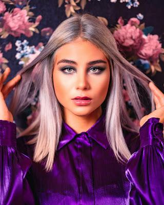 Mujer con los ojos grises perfilados en color morado Mujer con los ojos grises perfilados en color morado