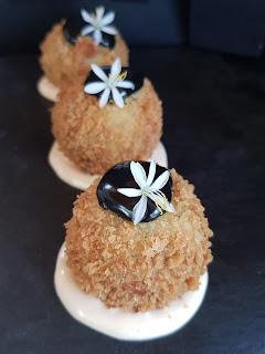 Croquetas gambas con algas wakame, leche de coco y parmesano, revuelta en panco y acompañada de alioli de ajo negro y mayonesa sriracha