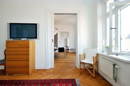 Decoración en armonía suelo de parquet en espiga mural de Times Square muebles de diseño mesa fritz hansen lámparas de diseño grandes ventanales estilo nórdico estilo escandinavo estilo de decoración sueco estampado de cebra en decoración diseño de interiores decoración de interiores consolas colgadas de la pared cocina blanca con isla