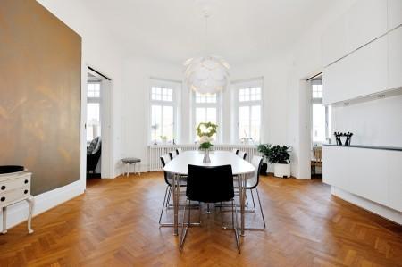 Decoración en armonía suelo de parquet en espiga mural de Times Square muebles de diseño mesa fritz hansen lámparas de diseño grandes ventanales estilo nórdico estilo escandinavo estilo de decoración sueco estampado de cebra en decoración diseño de interiores decoración de interiores consolas colgadas de la pared cocina blanca con isla