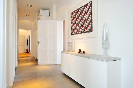 Decoración en armonía suelo de parquet en espiga mural de Times Square muebles de diseño mesa fritz hansen lámparas de diseño grandes ventanales estilo nórdico estilo escandinavo estilo de decoración sueco estampado de cebra en decoración diseño de interiores decoración de interiores consolas colgadas de la pared cocina blanca con isla