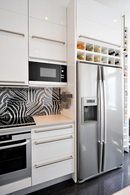 Decoración en armonía suelo de parquet en espiga mural de Times Square muebles de diseño mesa fritz hansen lámparas de diseño grandes ventanales estilo nórdico estilo escandinavo estilo de decoración sueco estampado de cebra en decoración diseño de interiores decoración de interiores consolas colgadas de la pared cocina blanca con isla