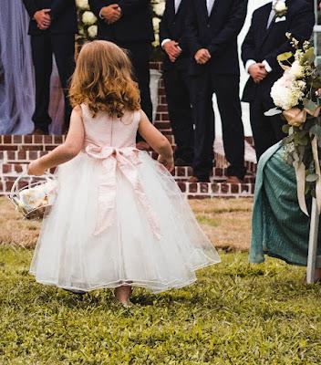 Niña pequeña llevando los pétalos en la ceremonia