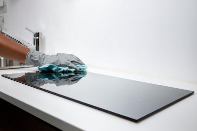 Persona limpiando una cocina de inducción