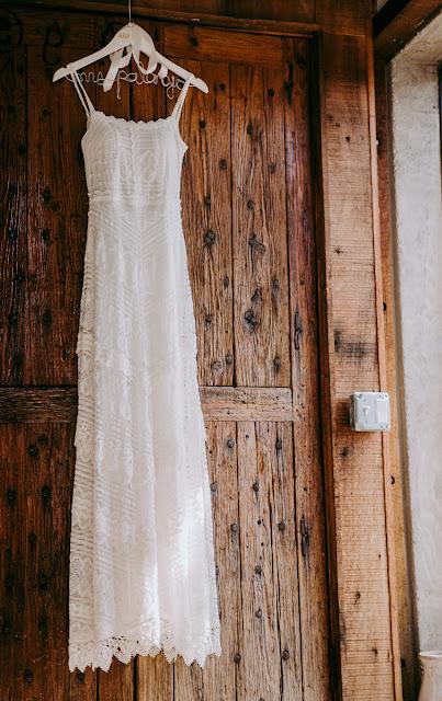 Vestido de novia de encaje colgado de una puerta