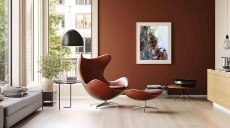 RincĂłn de lectura con sillĂłn de diseĂąo y obra de la serie Estratos del Tiempo, que evoca nostalgia y capas de memoria en tonos terrosos