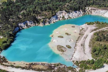 Lac Bleu de Guizengeard: camina a los lagos azules secretos de Charente Una antena de drones de lac bleu de Guizengeard que muestra el color turquesa lechoso del agua con algunas islas de arcilla blanca y el lago rodeado por un bosque de pinos