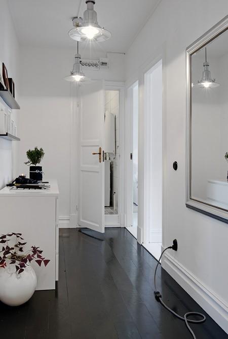 suelo madera negro sofá gris papel de pared negro con círculos papel de pared gris de cachemir muebles de diseño nórdico lámpara de bombillas estilo nórdico decoración espacio diáfano diseño de interiores decoración nórdica escandinava decoración de interiores decoración de espacios pequeños decoración con espejos cocina comedor salón unidos chandelier dorado 