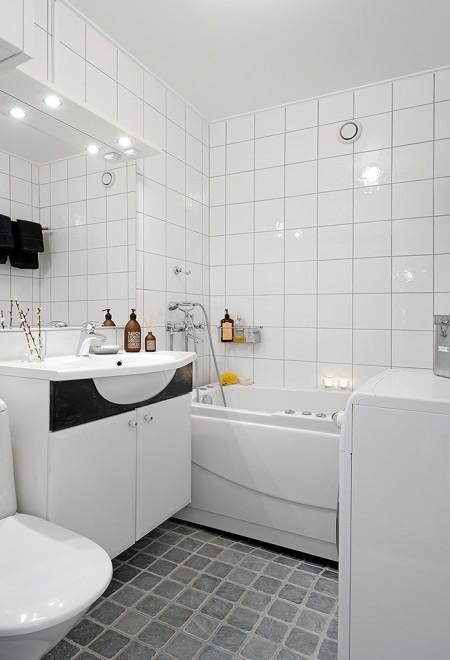 suelo madera negro sofá gris papel de pared negro con círculos papel de pared gris de cachemir muebles de diseño nórdico lámpara de bombillas estilo nórdico decoración espacio diáfano diseño de interiores decoración nórdica escandinava decoración de interiores decoración de espacios pequeños decoración con espejos cocina comedor salón unidos chandelier dorado 