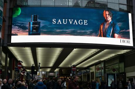 Digital out-of-home advertising screen displays a Dior Sauvage ad