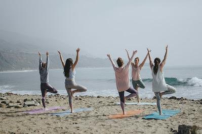 Personas haciendo yoga en la playa