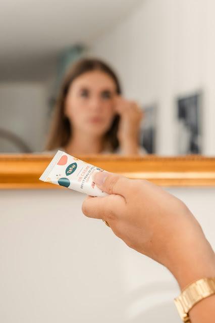 Mujer aplicándose una BB Cream frente al espejo Mujer aplicándose una BB Cream frente al espejo