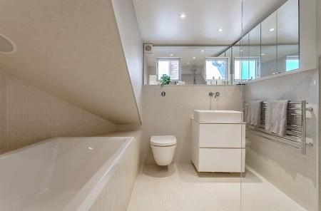 vigas y los pilares vista ventanas en el techo abuhardillado techos altos suelo blanco muebles zapateros mobiliario ligero estilo nórdico estilo escandinavo estanterías de obra en la ducha elemento decorativo diseño de interiores decoración nórdica decoración en blanco decoración de interiores decoración áticos loft altillo y escaleras espacio de trabajo 