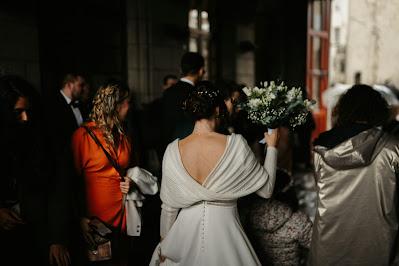 Novia con el ramo en la mano saliendo de la ceremonia entre la multitud