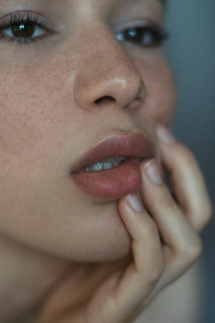 Mujer sujetándose la cara con una mano Mujer sujetándose la cara con una mano