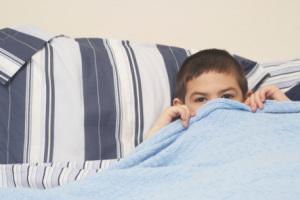 Niño en la cama sin dormir